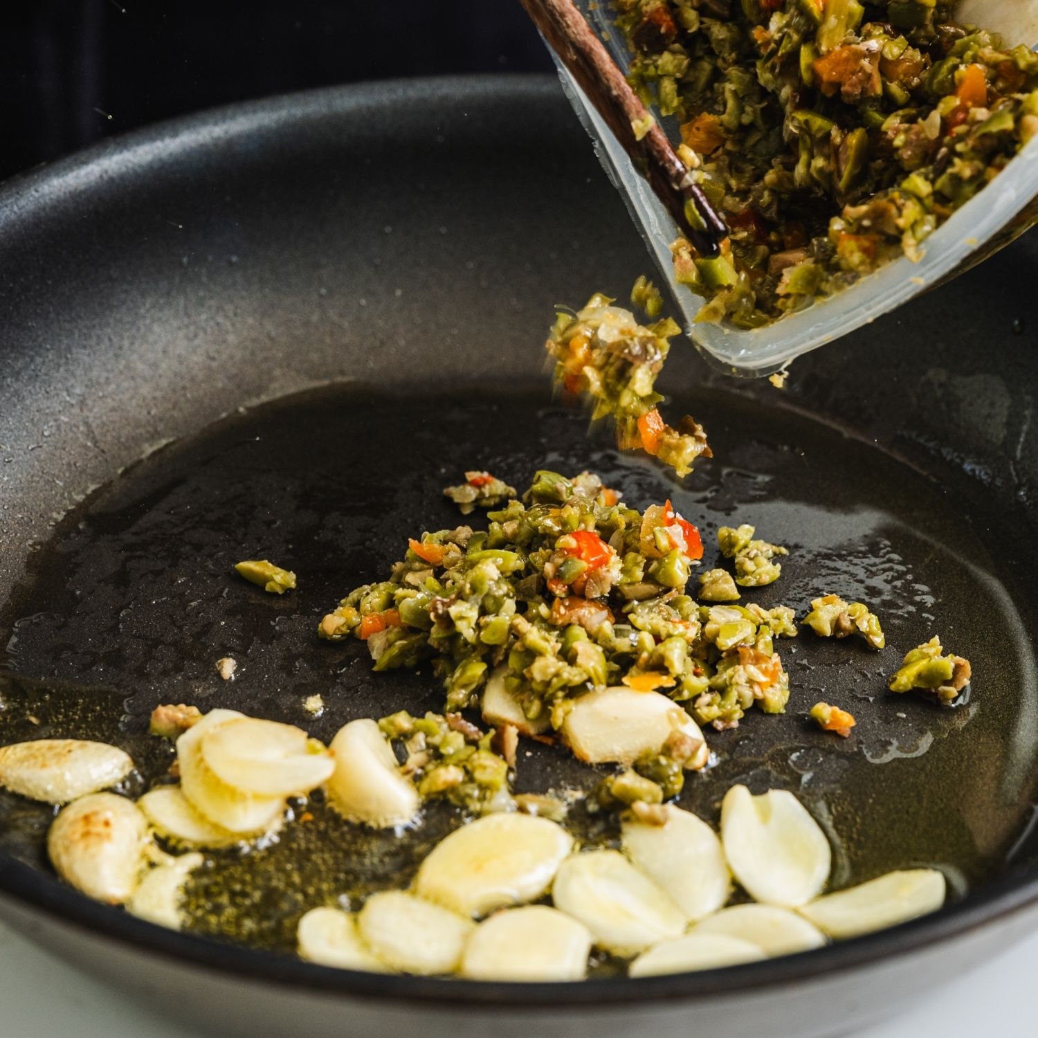 마늘이 연한 황금빛이 되면 다진 올리브를 넣고 가볍게 볶아주세요.