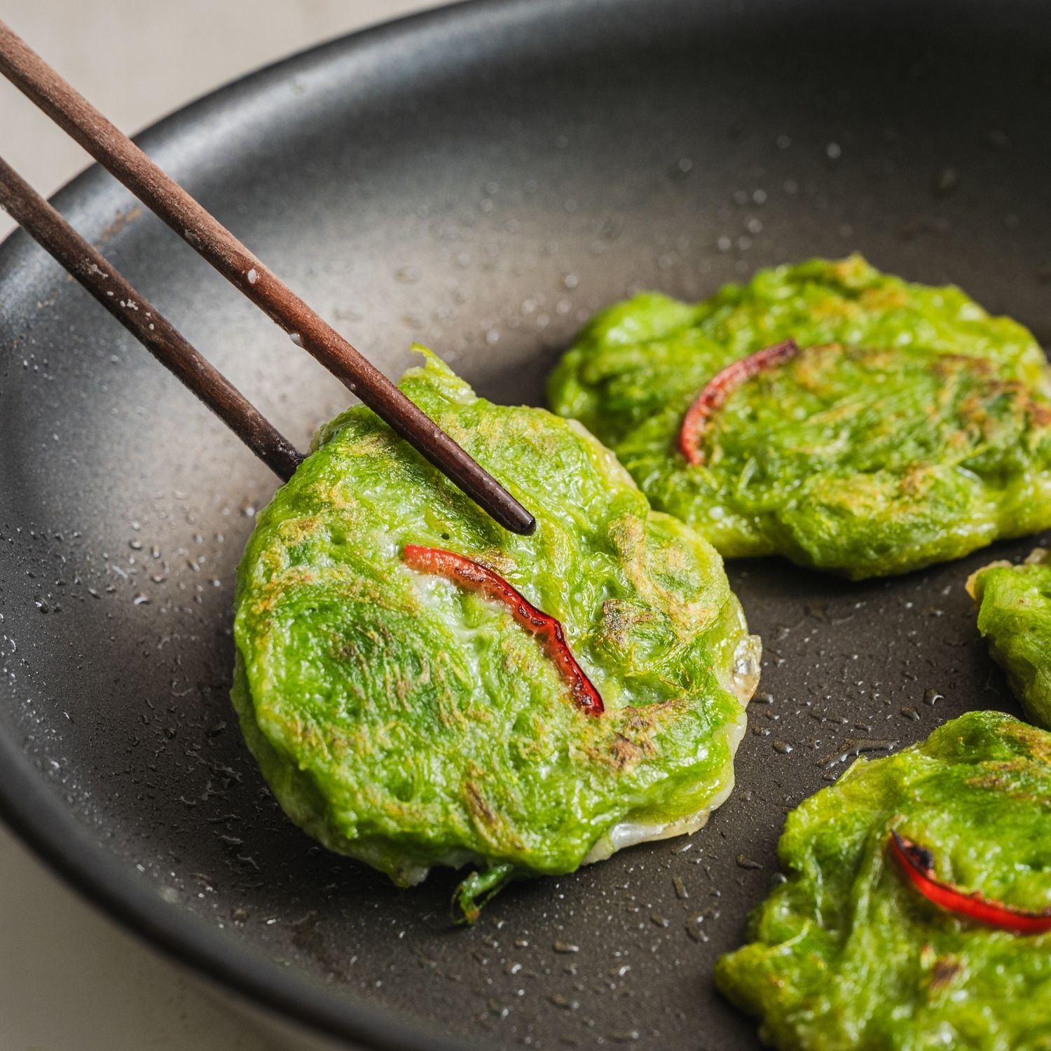 팬에 식용유를 두르고 중불로 달궈준 후반죽을 한 숟갈씩 떠 올려 앞뒤로 노릇하게 부쳐주세요. 따뜻할 때 간장이나 초장을 곁들여 맛있게 즐겨주세요.