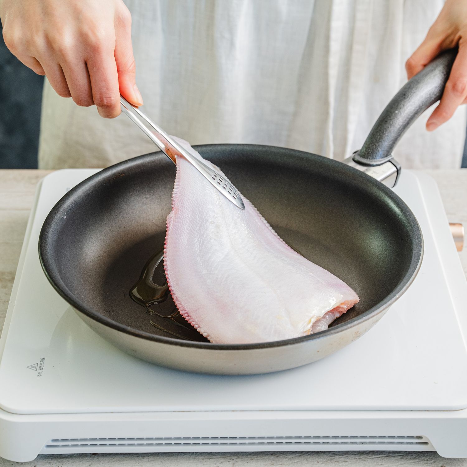 팬에 식용유를 넉넉히 두르고 중불로 달군 뒤 가자미를 올려주세요.