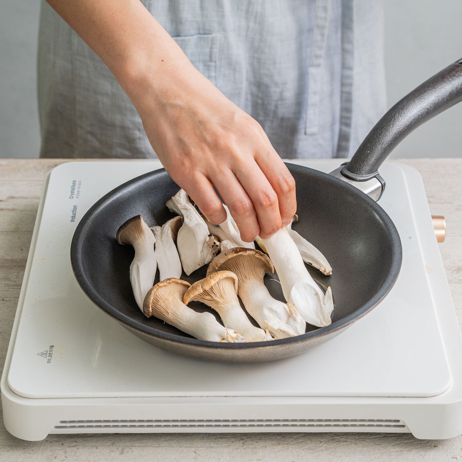 팬을 중불로 달군 뒤 식용유를 두르고 버섯을 넓게 펼쳐 올려주세요. 