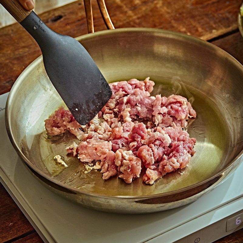 팬에 식용유를 두르고 중불에서 다진 돼지고기를 볶아주세요.