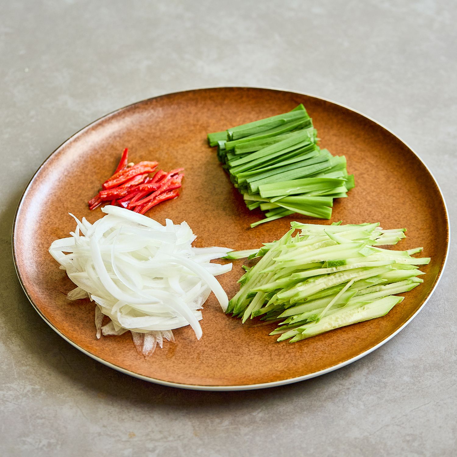 양파는 얇게 채 썰고, 부추는 4~5cm 길이로 썰어주세요. 오이는 어슷썰은 후 채를 썰고 홍고추는 씨를 제거한 뒤 가늘게 채를 썰어주세요.  