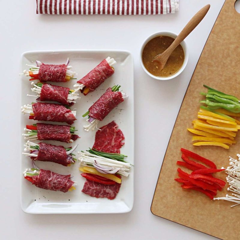 볼에 소스재료를 넣고 고루 섞어주세요.
쇠고기 위에 썰어놓은 야채를 올려 돌돌 말아주세요.