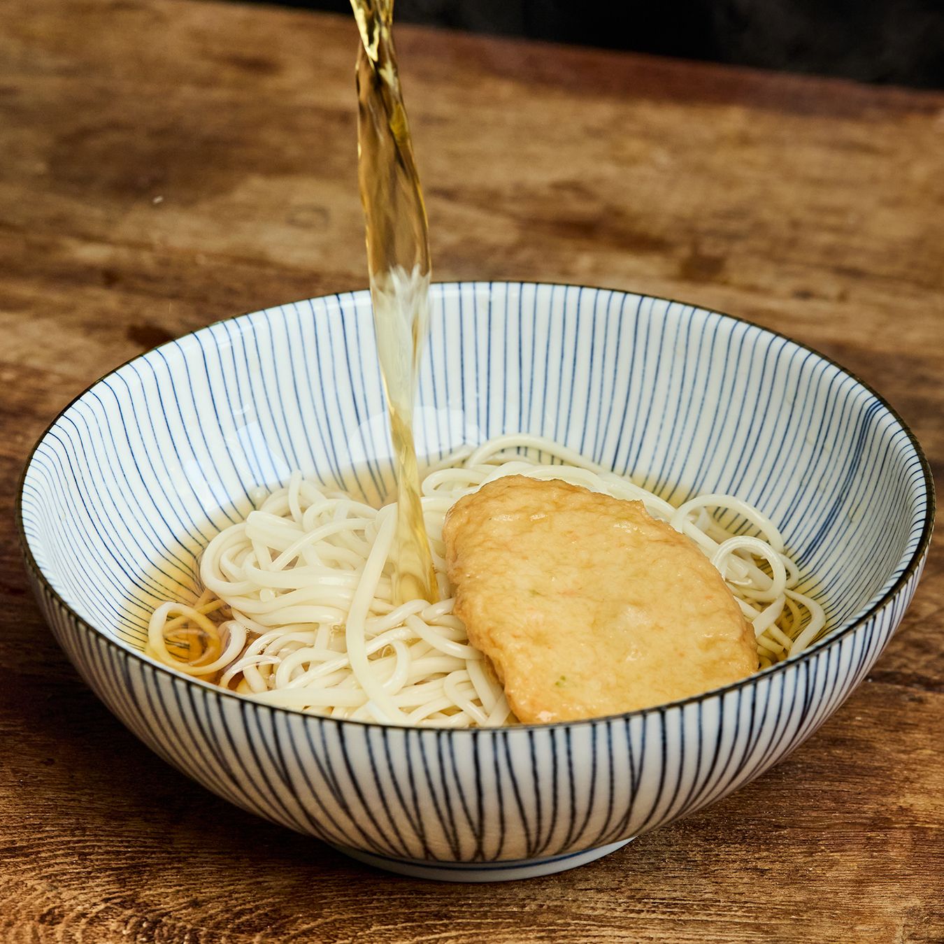 육수에 어묵을 넣어 끓인 후 우동면에 붓고 시치미 고명을 뿌려 완성해주세요. 