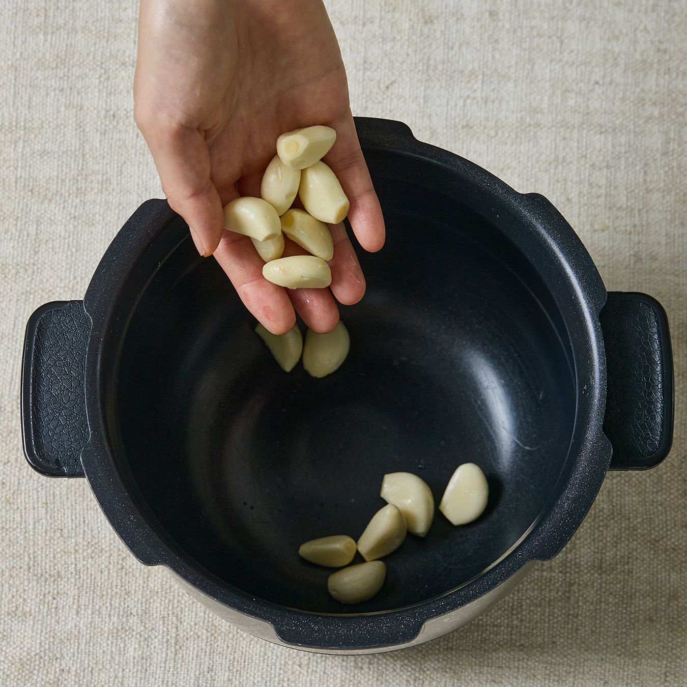 밥통 바닥에 통마늘을 넣고 닭고기를 올린 뒤 맛술과 물을 부어주세요.

