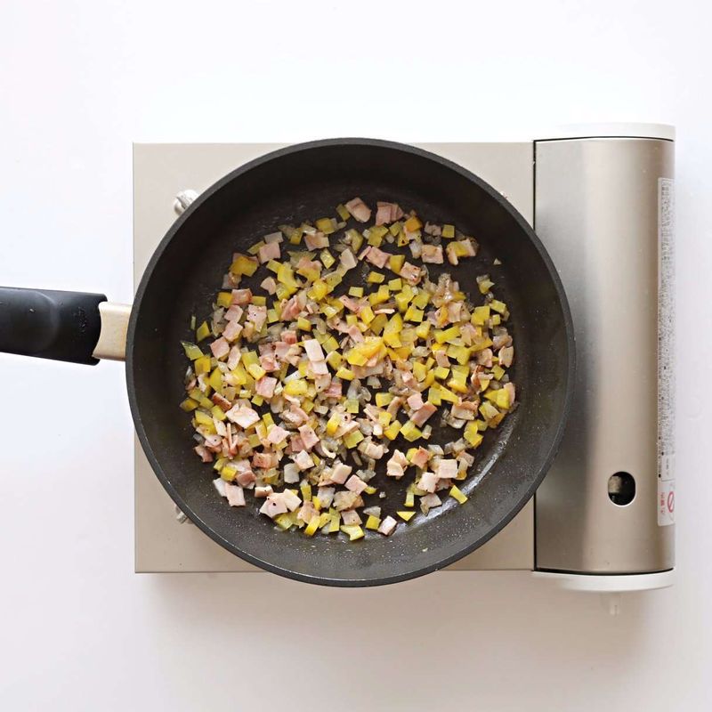 달군 팬에 약간의 올리브유를 두르고 베이컨, 양파, 파프리카를 넣은 후 약간의 소금과 후추를 넣어 볶아주세요.