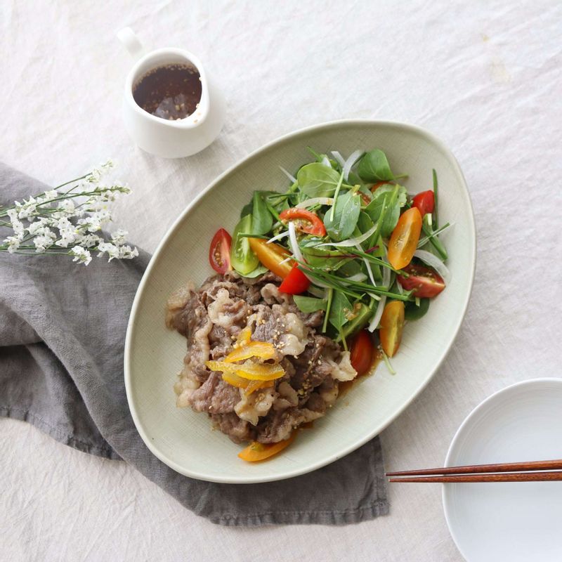 접시에 영양부추와 양파, 어린잎새싹, 토마토를 섞어 한 쪽에 담고, 다른 한 쪽에 차돌박이를 담은 후 드레싱을 뿌려주세요.