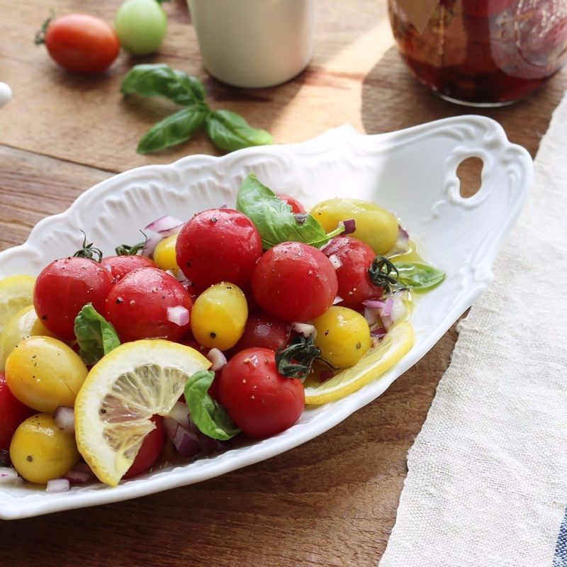 볼에 방울토마토와 적양파, 레몬을 넣고 드레싱을 넣어 가볍게 섞은 후 바질잎을 올려주세요.