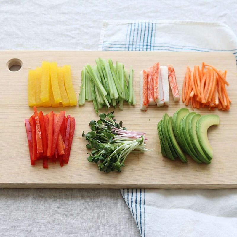 단무지는 먹기 좋은 길이로 자르고 크래미, 오이, 파프리카는 채를 썰어주세요. 아보카도는 반으로 잘라 씨를 뺀 후 껍질을 벗겨 먹기 좋은 크기로 썰어주세요.