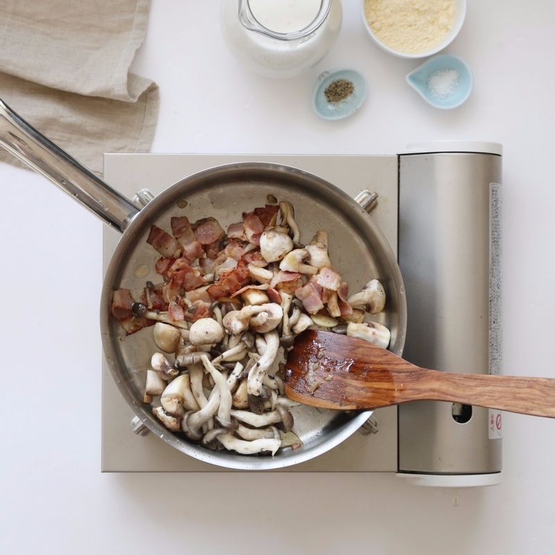 팬에 버터를 두르고 마늘편과 다진양파, 베이컨을 넣어 2분 정도 볶아주세요.