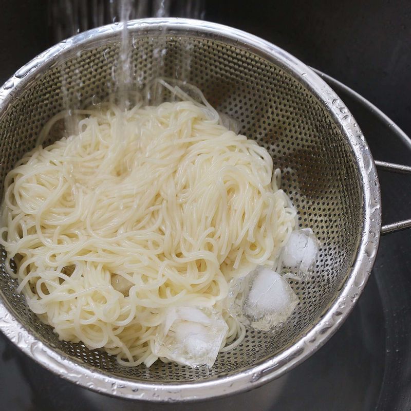 흐르는 찬물에 중면을 여러 번 씻어 전분기를 없애고, 돌돌 말아 채반에 밭쳐 물기를 빼 주세요.