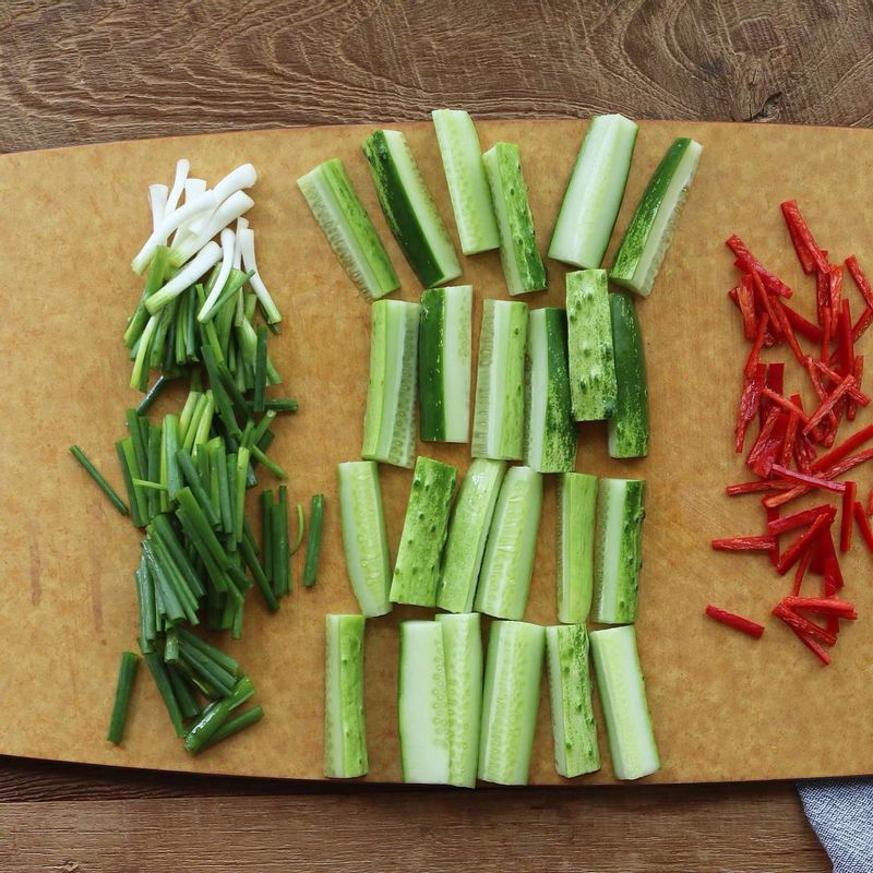 오이는 굵은 소금으로 문질러 씻어 4토막으로 자른 후, 다시 6등분해서 썰어주세요. 쪽파는 4센치 길이로 썰고, 홍고추는 3센치 길이로 채를 썰어주세요