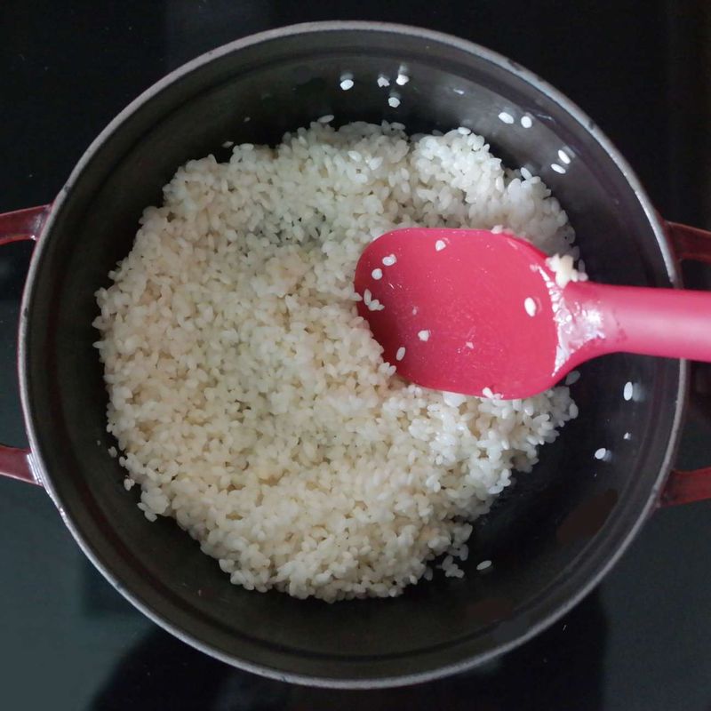 달군 냄비에 참기름을 두르고 불린 쌀, 다진 마늘을 넣어 쌀알이 투명해질 때까지 볶아주세요.