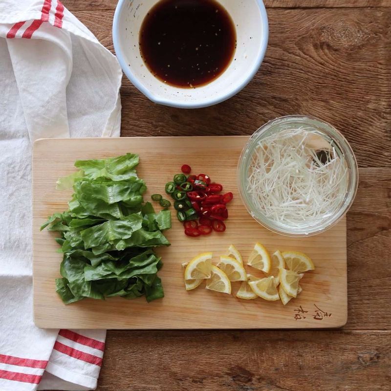로메인은 굵게 채썰고, 대파 흰부분은 반으로 가른 후 6cm 길이로 곱게 채썰어주세요. 청양고추와 홍고추를 링으로 썰고, 레몬은 얇게 슬라이스해서 소스재료와 섞어주세요.