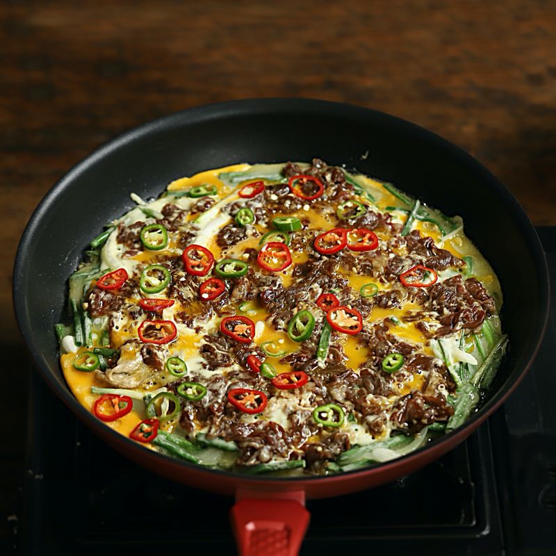 풀어 놓은 달걀과 청,홍고추를 넣고 뒤집어 약불에서 2분간 구워주세요.