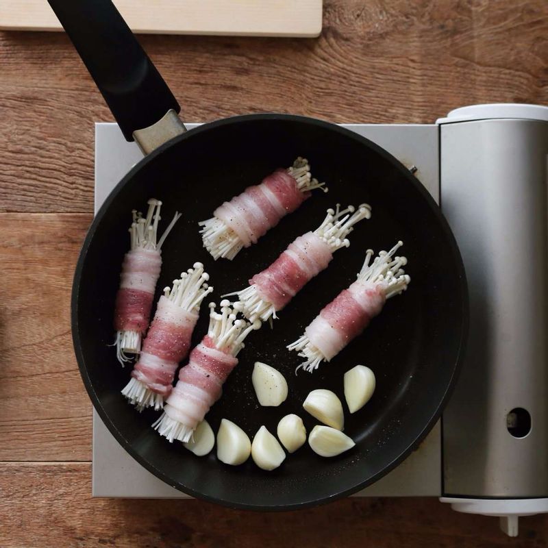 달군 팬에 약간의 기름을 두르고, 삼겹살 말이와 마늘을 넣은 후 약간의 소금, 후추를 뿌려 노릇하게 구워 주세요. (삼겹살 말이의 이음새 부분부터 익혀주세요.)