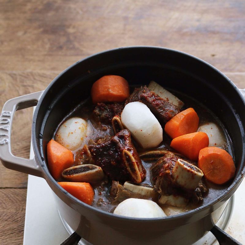 냄비에 양념한 갈비와 갈비 삶은 국물 2컵, 무, 당근을 넣고 20분정도 끓여주세요.