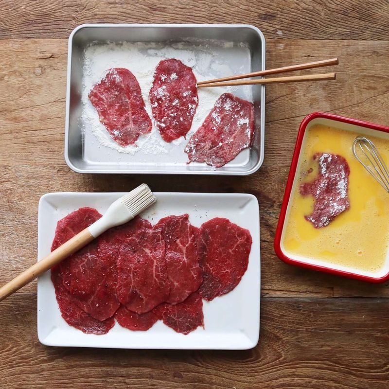 밑간한 쇠고기에 부침가루 묻혀 탁탁 털어낸 후, 풀어놓은 달걀물을 입혀주세요.