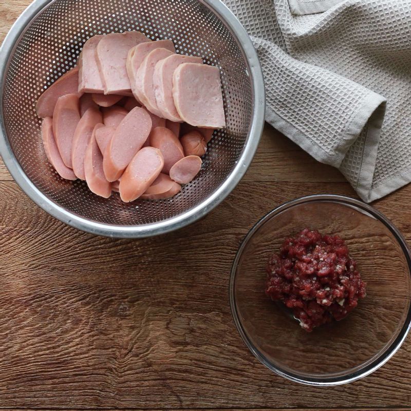 햄과 소시지는 먹기 좋게 자른 후 체에 밭쳐 끓는 물을 살짝 부어 기름기를 제거해주세요. 다진쇠고기는 양념에 10분 정도 재워주세요.
