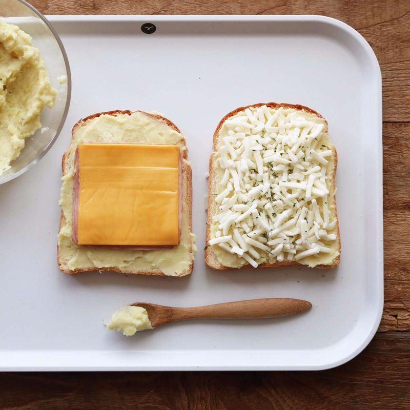 식빵 한쪽 면에 고구마무스를 바르고, 햄 2장-슬라이스 치즈-피자치즈-다른 식빵-고구마무스-피자치즈-파슬리가루 순으로 올려주세요.