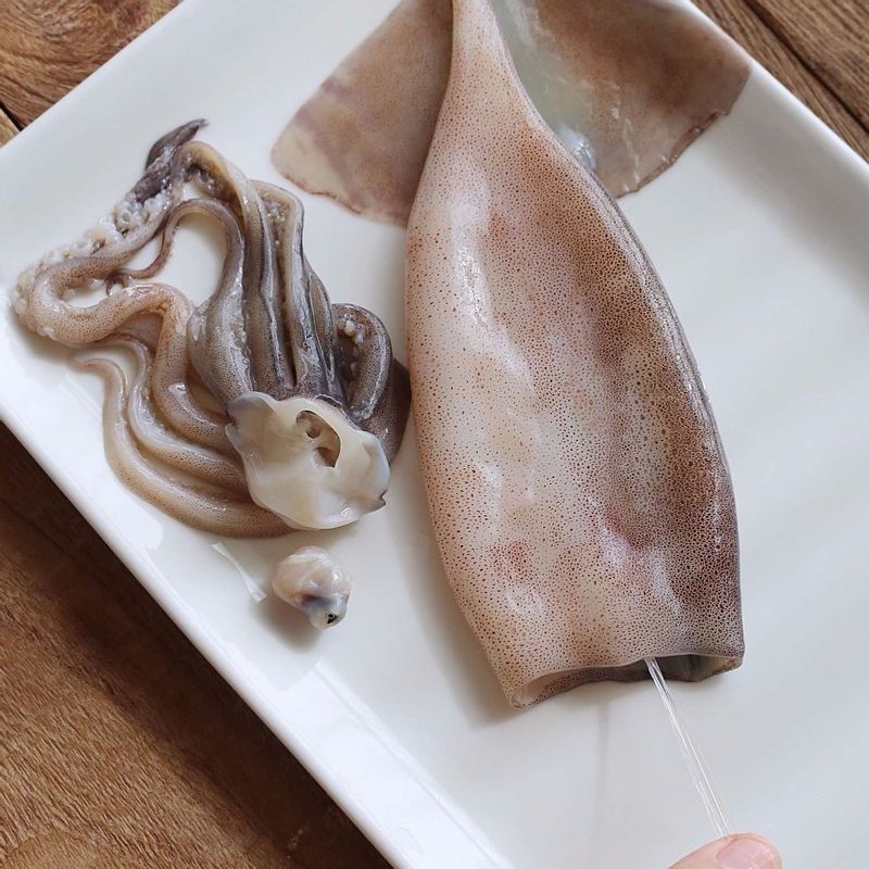 오징어는 배를 가르지않고 내장과 뼈를 빼낸 후, 다리에 붙어있는 눈과 입을 제거해주세요. 오징어를 깨끗이 씻어 물기를 제거하고, 가운데 부분이 2센치정도 남게 양 옆으로 칼집을 넣어주세요.