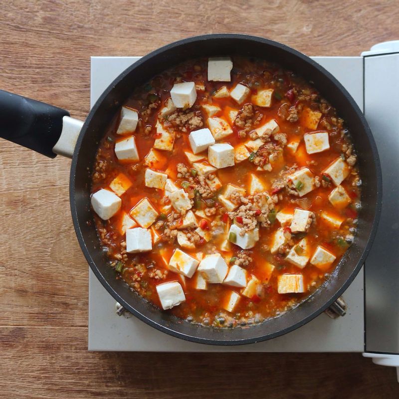 국물이 끓어오르면 두부를 넣고, 녹말물을 조금씩 넣으면서 농도를 걸쭉하게 맞춰 주세요. 참기름을 두르고 불을 꺼주세요.