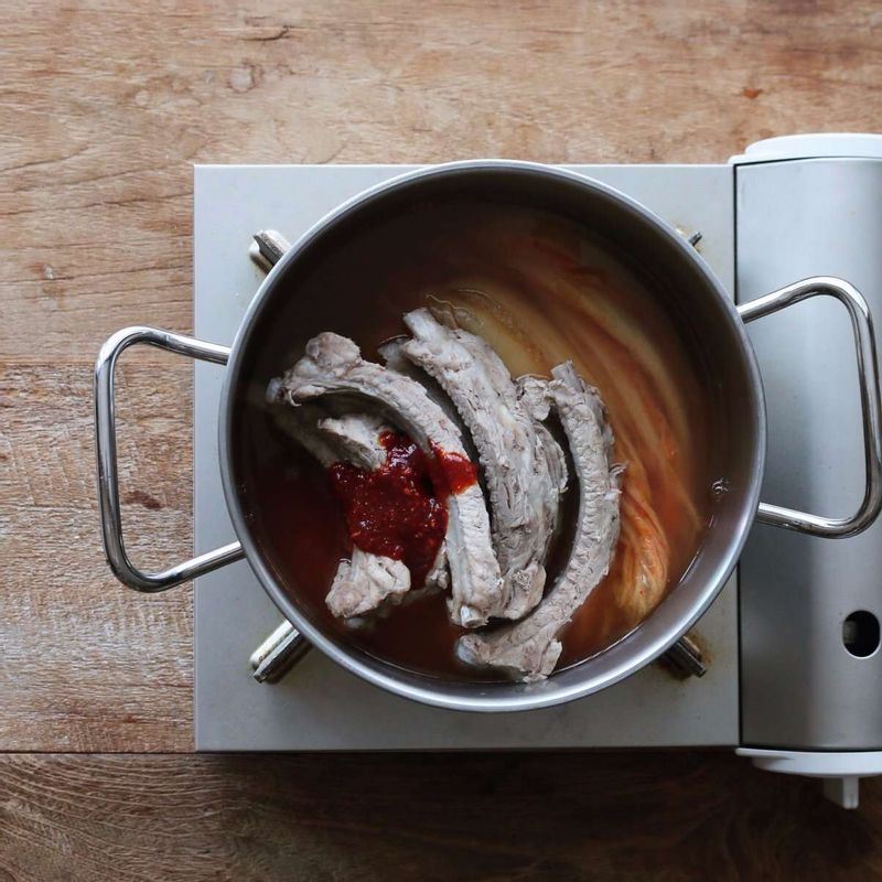 냄비에 김치를 깔고 등갈비를 올린 후, 양념재료와 다시마멸치육수 3컵을 넣고 20분정도 끓여주세요.