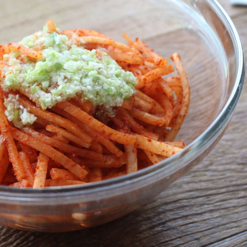 고춧가루에 물들인 무채에 양념재료를 넣고 조물조물 버무려주세요.