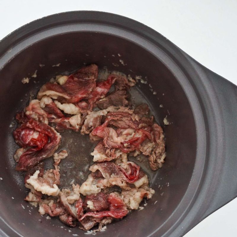 달군 냄비에 차돌박이와 다진 마늘을 넣고 중불에서 볶아주세요.