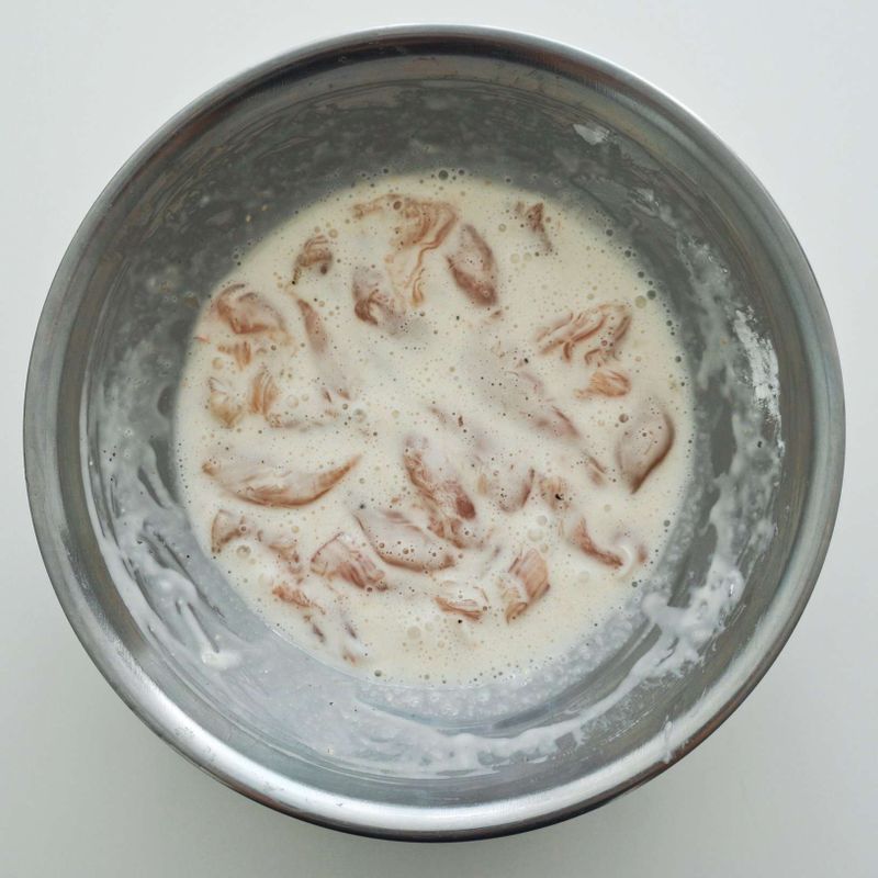 볼에 닭고기 안심살을 넣고 우유를 부운 후 10분 정도 재우고 흐르는 물에 씻어 물기를 제거해요. 먹기 좋은 크기로 자른 후 생강즙, 소금, 후춧가루를 뿌려 밑간해요. 밑간한 닭고기는 볼에 달걀흰자, 녹말 4큰술과 함께 넣고 잘 섞어주세요.