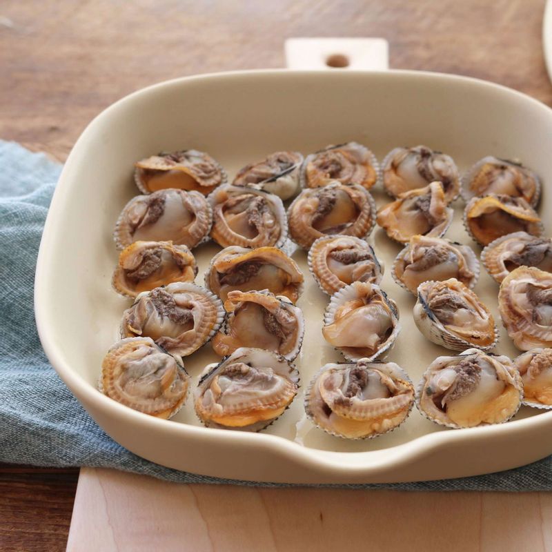 접시에 한쪽 껍데기가 붙은 꼬막을 담고, 양념장을 고루 얹은 후 깨를 뿌려주세요.