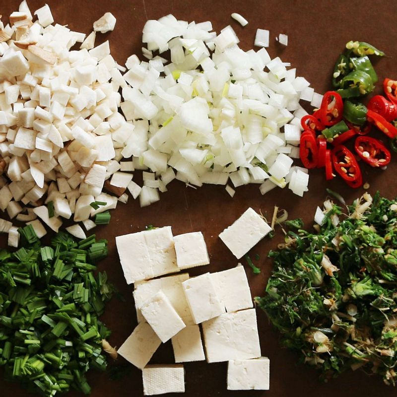 두부는 한입 크기로 깍둑썰기 하고 양파, 새송이버섯, 고추, 부추는 잘게 썰어주세요. 냉이와 돌나물을 깨끗이 씻은 후 먹기 좋은 크기로 썰어주세요.