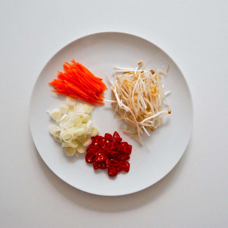 당근은 얇게 채를 썰고, 홍고추와 대파는 송송 썰어주세요. 숙주는 흐르는 물에 씻어주세요.