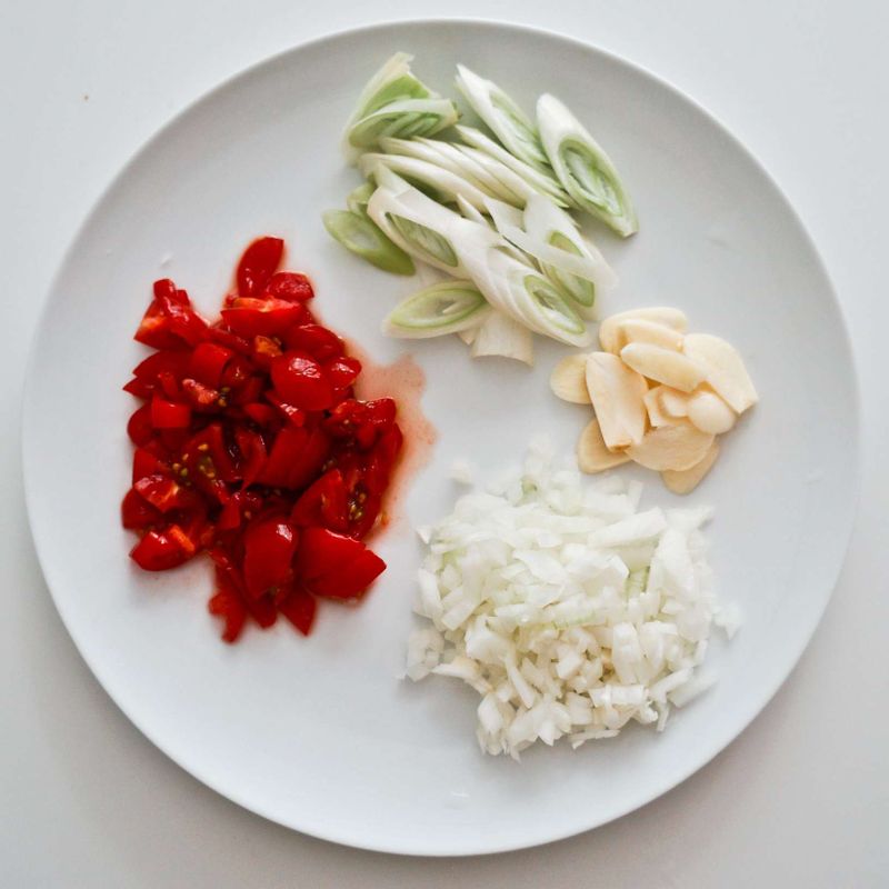 대파는 어슷하게 썰고, 마늘은 얇게 편으로 썰고, 양파는 잘게 다지고, 방울토마토는 잘게 썰어주세요.