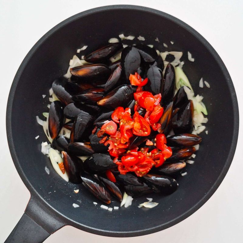 달군 팬에 올리브오일을 두르고 마늘을 넣은 후 중불에서 향이 올라올 때까지 볶다가 양파와 대파를 넣어 함께 볶아주세요.
홍합, 방울토마토와 화이트와인, 페페론치노를 넣고 볶아주세요.