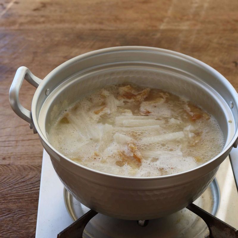 국물이 뽀얗게 우러나면 무를 넣어주세요. 무가 익으면 콩나물과 국물양념을 넣어 2분 정도 더 끓여주세요.