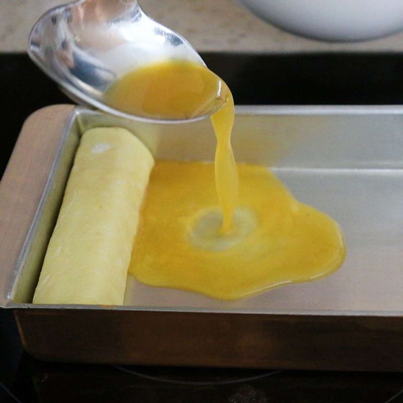 달걀물이 반 정도 익으면 맛살을 감싸듯이 돌돌 말아주세요.