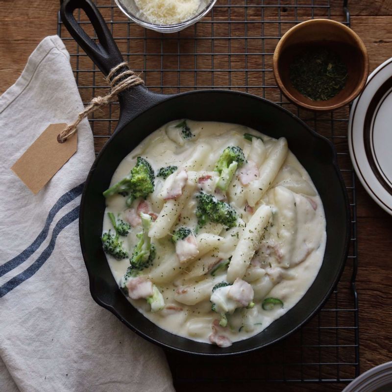 접시에 까르보나라 떡볶이를 담고, 파마산치즈가루와 파슬리가루를 뿌려주세요.