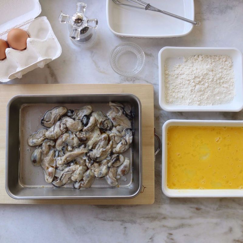 굴에 부침가루를 고루 묻힌 후 탁탁 털고, 달걀물을 입혀주세요.