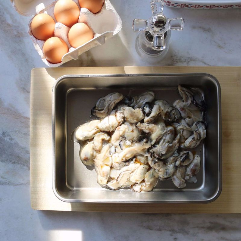 굴은 약간의 소금을 넣은 찬물에 가볍게 흔들어 씻어 불순물을 제거해주세요. 체에 밭쳐 물기를 뺀 후 볼에 담아 굴 밑간 재료에 10분 정도 밑간해주세요.