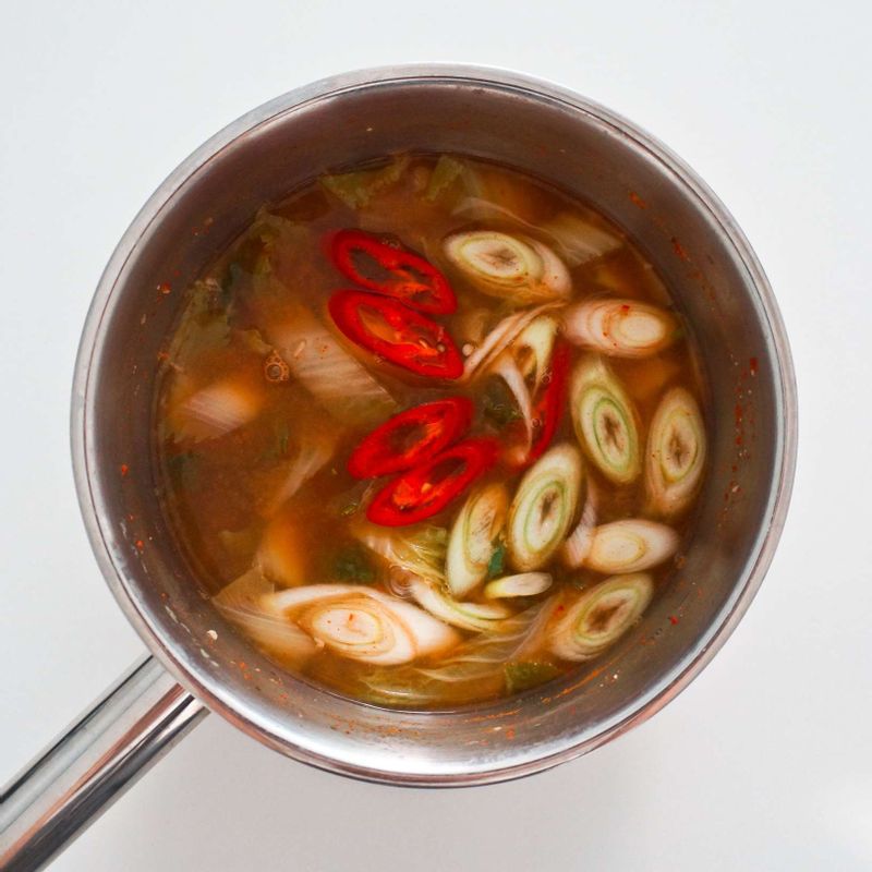 육수가 끓어오르면 봄동과 다진마늘 1/2큰술을 넣고 중불에서 15분정도 끓여주세요.