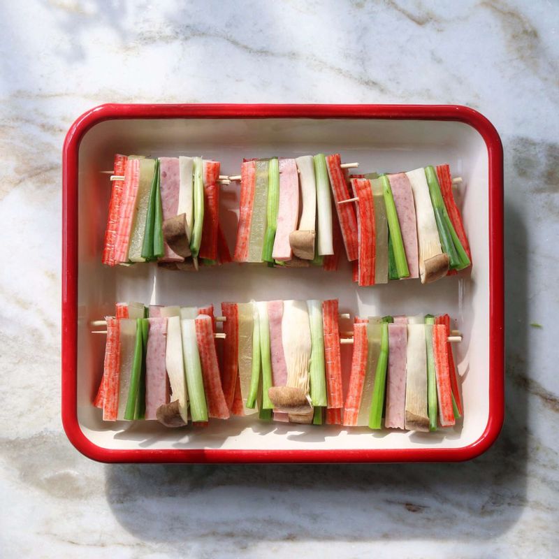 나무꼬치에 게맛살-쪽파-새송이버섯-햄-쪽파-단무지-게맛살 순으로 꽂아주세요.