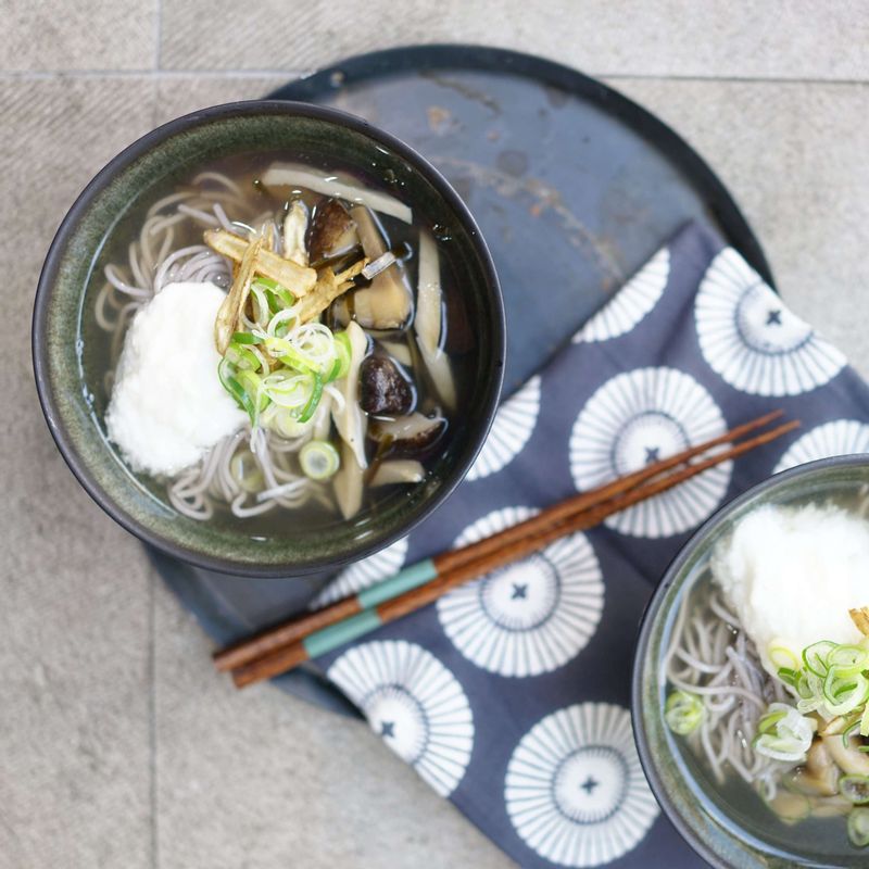 그릇에 메밀 국수를 담고 간 마, 튀긴 우엉, 표고 다시마 새송이 졸인 것을 올리고 마지막으로 다시마 표고 국물을 부어 완성해주세요.