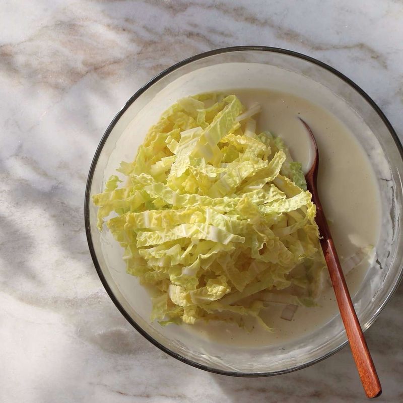 볼에 반죽 재료를 넣고 섞은 후, 채 썬 배추를 넣어 섞어주세요.