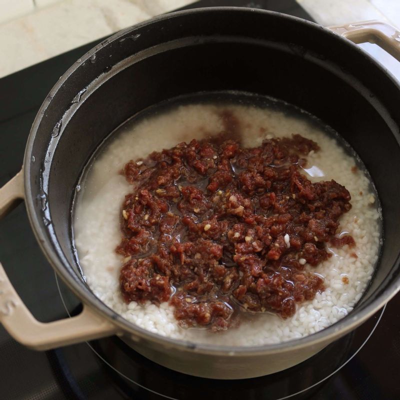 냄비에 불린쌀과 쇠고기를 담고 물을 넣어 센불에서 끓이다가, 끓어오르면 약불로 줄여 12분 정도 뚜껑을 닫고 끓여주세요.