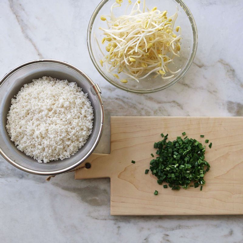 쌀은 씻어 30분 정도 찬물에 불렸다가 체에 밭쳐 물기를 빼주세요. 콩나물은 꼬리를 다듬어 씻고, 부추는 송송 썰어주세요.