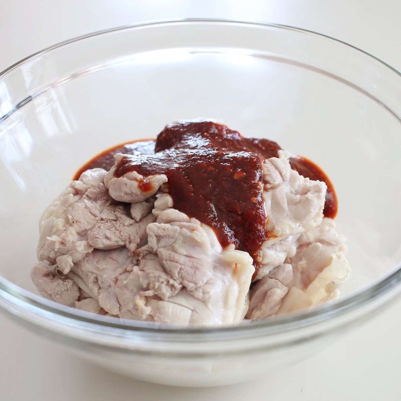 끓는 물에 청주와 닭다리살을 넣고 살짝 데친 후 흐르는 물에 씻고 군데군데 칼집을 넣어주세요. 양념 재료를 섞어 닭다리살에 버무려 10분간 재우세요.