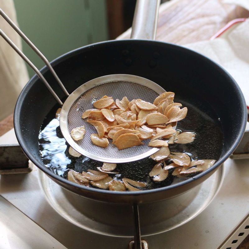 팬에 기름을 넉넉히 두르고, 마늘을 노릇하게 튀겨주세요.