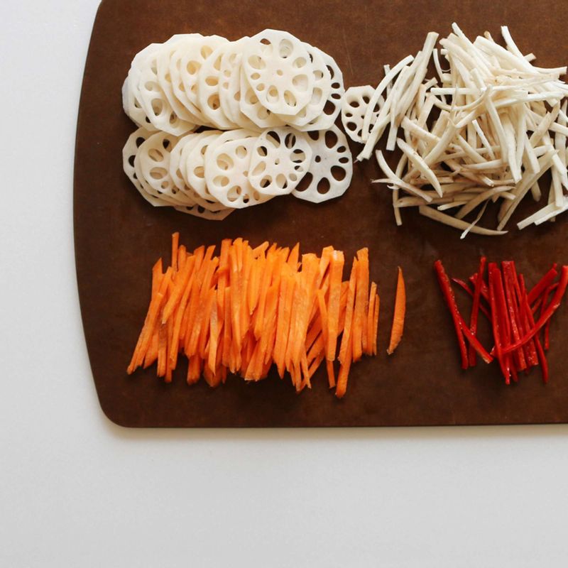 연근은 껍질을 벗기고 난 후 동그란 모양으로 얇게 썰어주세요. 우엉, 당근은 필러로 껍질을 벗기고 4~5cm 길이로 채 썰어주세요. 홍고추도 비슷한 크기로 채 썰어주세요.