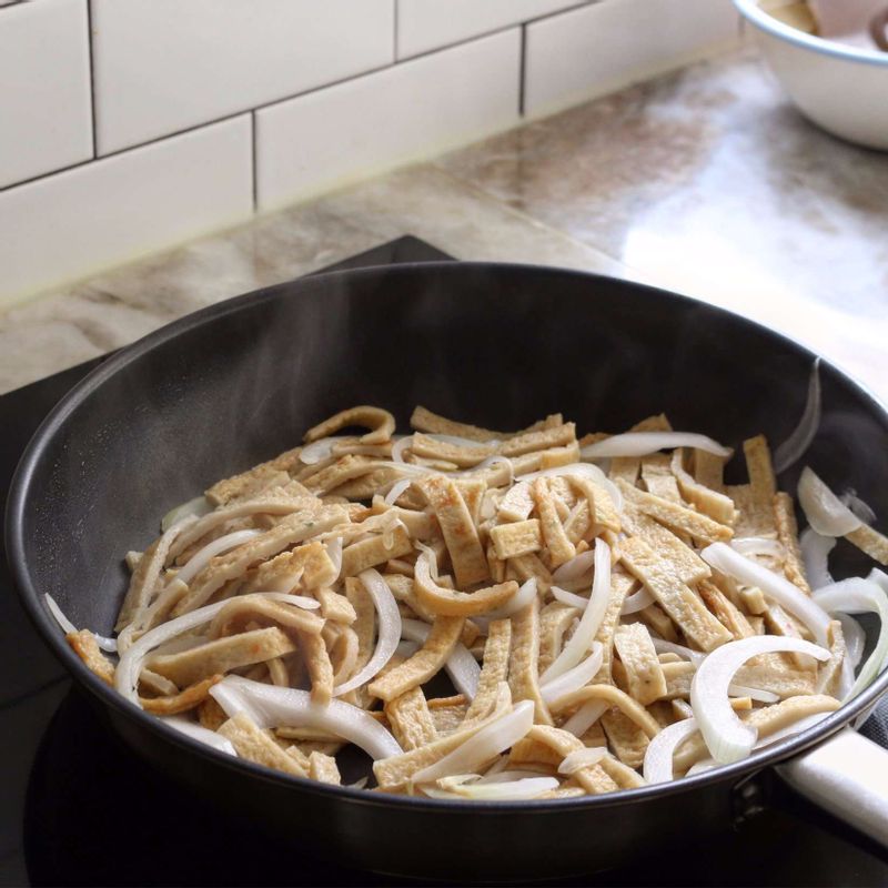 팬에 약간의 기름을 두르고, 어묵과 양파를 넣어 중약불에서 볶아주세요.